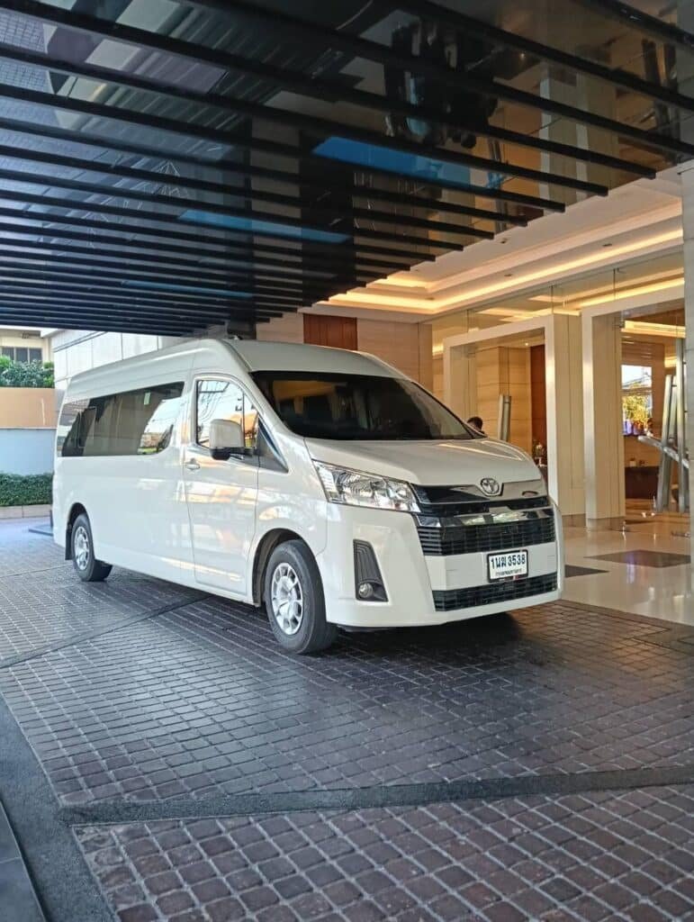 Modern white passenger van waiting at a hotel for a private Ayutthaya day tour.